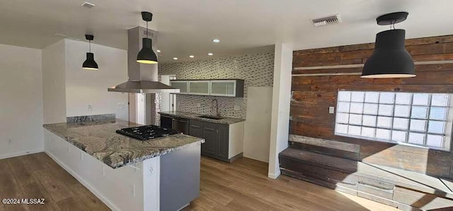 kitchen featuring island range hood, sink, kitchen peninsula, and hardwood / wood-style floors