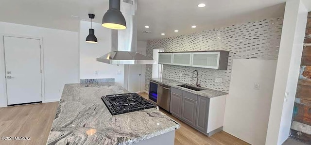 kitchen with decorative backsplash, hanging light fixtures, sink, gray cabinets, and stainless steel dishwasher