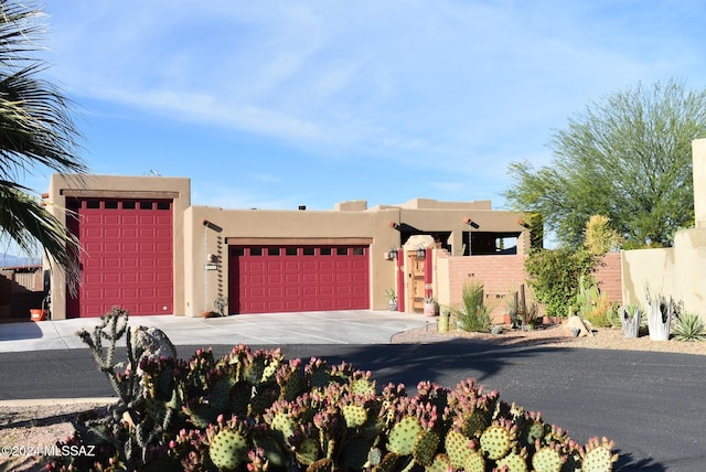 pueblo revival-style home featuring a garage