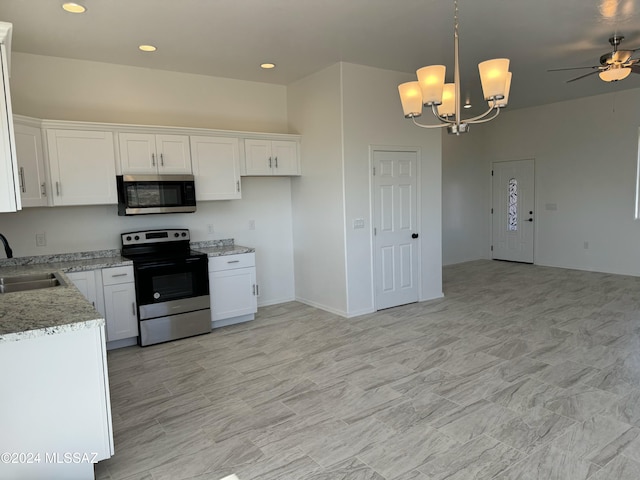 kitchen featuring sink, hanging light fixtures, appliances with stainless steel finishes, white cabinets, and ceiling fan with notable chandelier