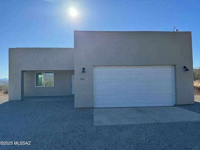 pueblo revival-style home with a garage