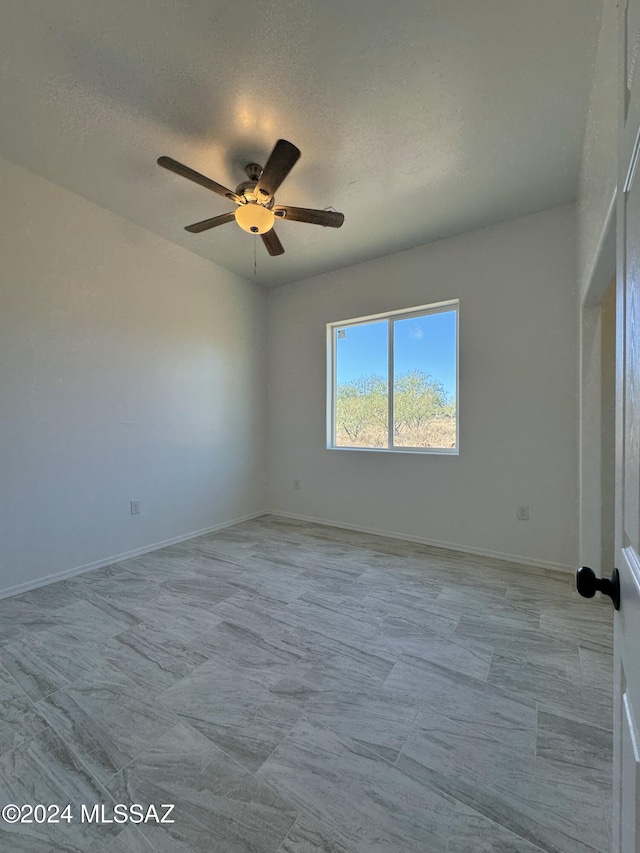 spare room featuring ceiling fan and a textured ceiling