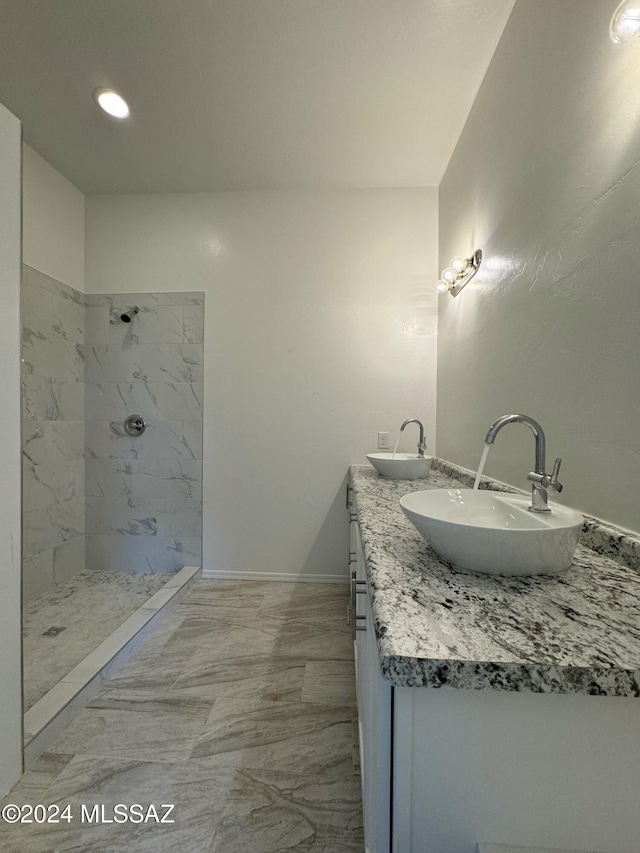 bathroom with vanity and a tile shower