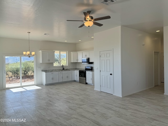 kitchen featuring decorative light fixtures, sink, appliances with stainless steel finishes, white cabinets, and ceiling fan with notable chandelier