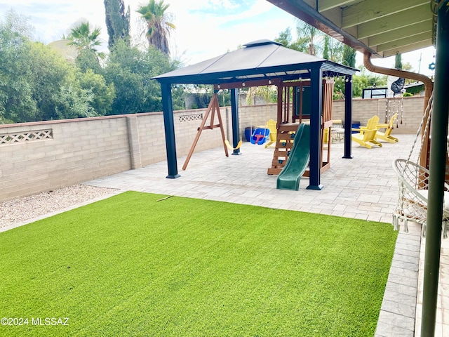 view of play area with a lawn and a patio