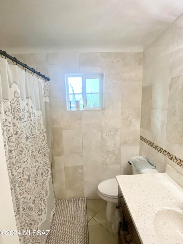 bathroom featuring tile patterned floors, vanity, tile walls, and walk in shower