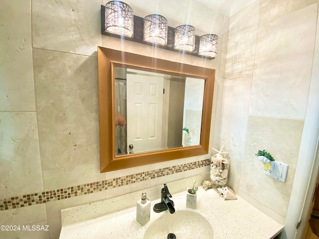 bathroom with vanity, tile walls, and tasteful backsplash