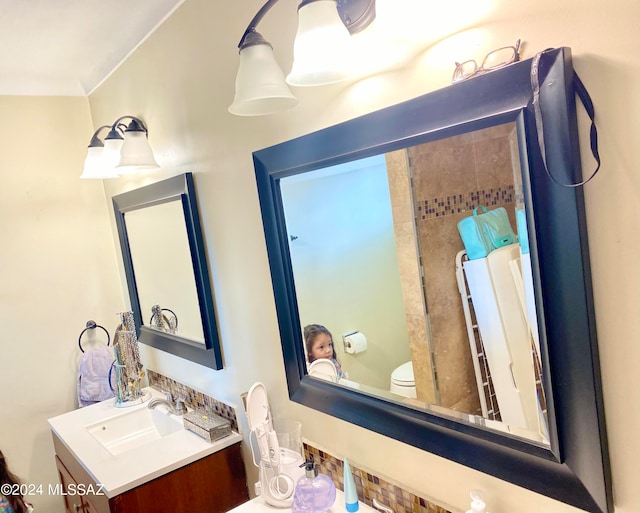 bathroom with crown molding, vanity, and toilet