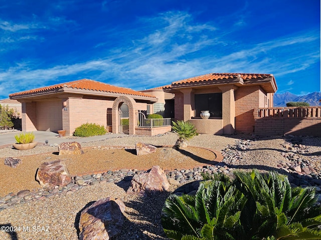 mediterranean / spanish home with a garage and a mountain view