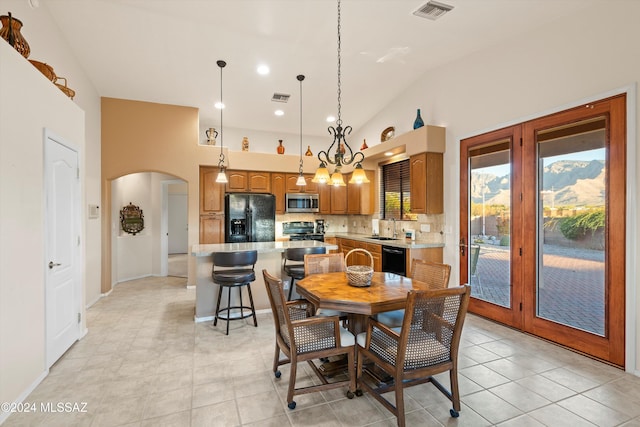 tiled dining area featuring lofted ceiling, sink, and an inviting chandelier