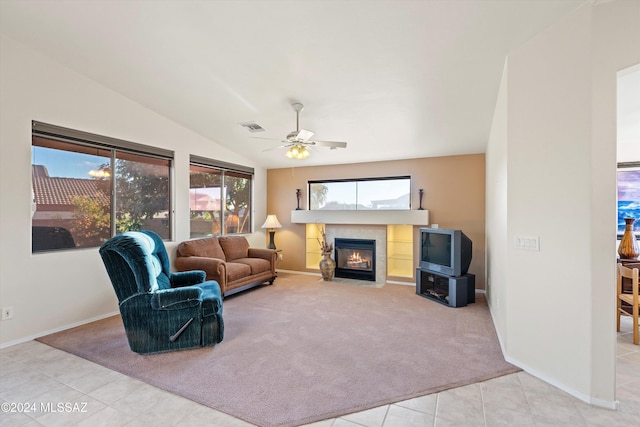 tiled living room featuring ceiling fan, lofted ceiling, and a fireplace