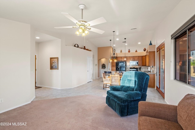 carpeted living room with ceiling fan and vaulted ceiling