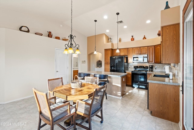 dining space featuring light tile patterned floors, sink, high vaulted ceiling, and a chandelier