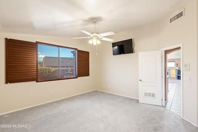 carpeted empty room with vaulted ceiling and ceiling fan