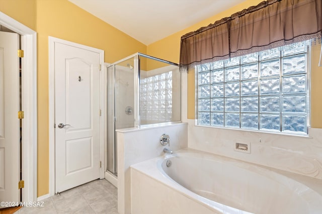 bathroom featuring plus walk in shower, lofted ceiling, tile patterned floors, and a healthy amount of sunlight