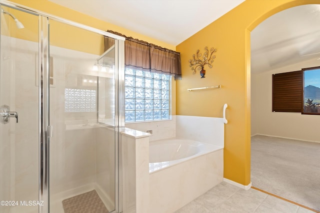 bathroom featuring tile patterned flooring, independent shower and bath, and lofted ceiling