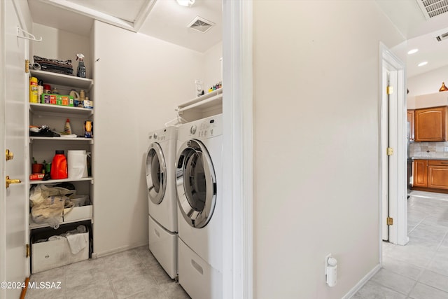 laundry area with independent washer and dryer and light tile patterned floors