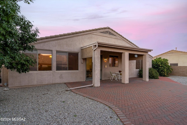 back house at dusk with a patio