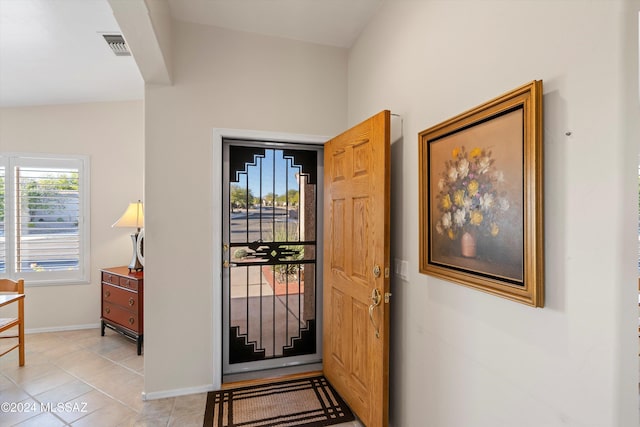 entryway featuring lofted ceiling and light tile patterned flooring