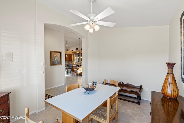 dining area featuring light tile patterned floors, vaulted ceiling, and ceiling fan