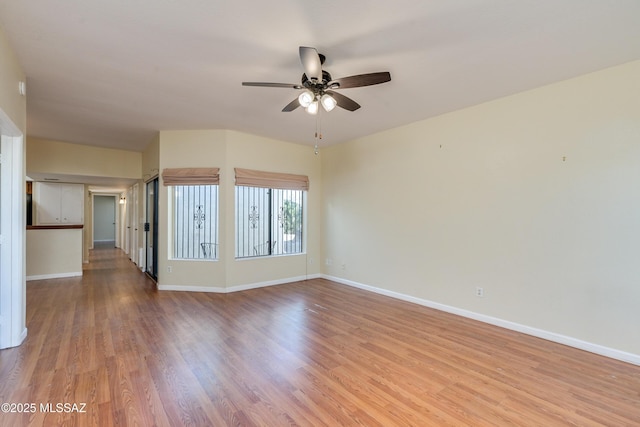 unfurnished room featuring light wood finished floors, ceiling fan, and baseboards