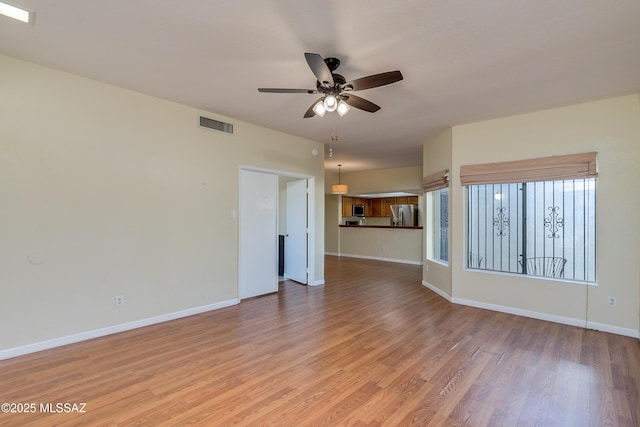 unfurnished living room featuring ceiling fan, light wood-type flooring, visible vents, and baseboards