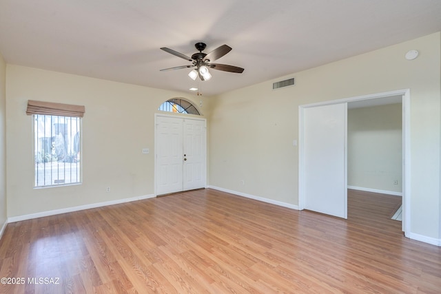 empty room with baseboards, ceiling fan, visible vents, and light wood-style floors