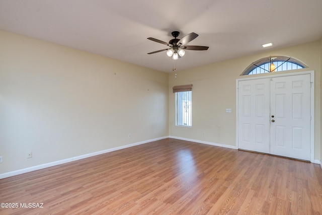 entrance foyer featuring a ceiling fan, a wealth of natural light, baseboards, and light wood finished floors