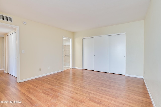 unfurnished bedroom featuring a closet, baseboards, visible vents, and light wood finished floors