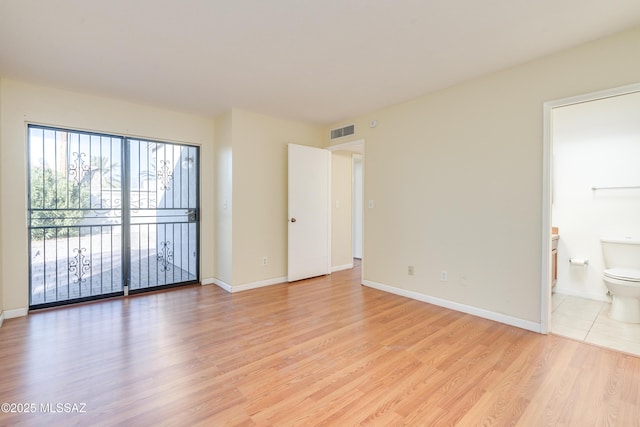 unfurnished bedroom with access to exterior, visible vents, light wood-style floors, and baseboards