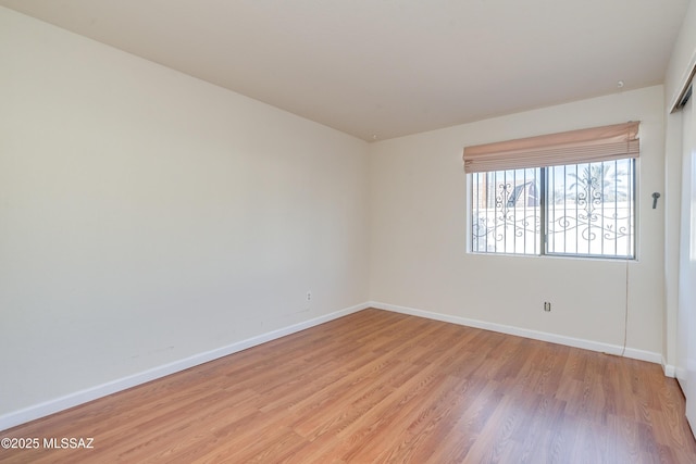 empty room featuring light wood-style flooring and baseboards