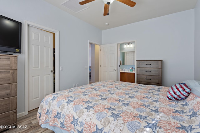 bedroom featuring ceiling fan, ensuite bath, and light wood-type flooring