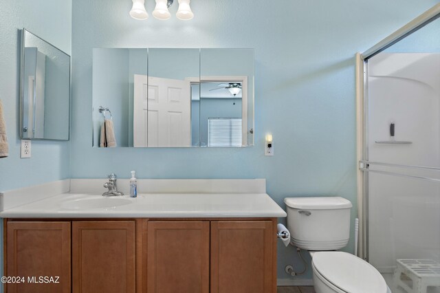 bathroom featuring a shower, ceiling fan, vanity, and toilet