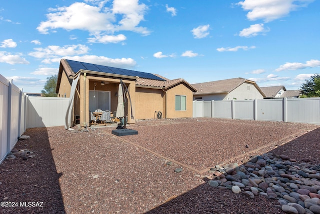 back of house featuring solar panels and a patio