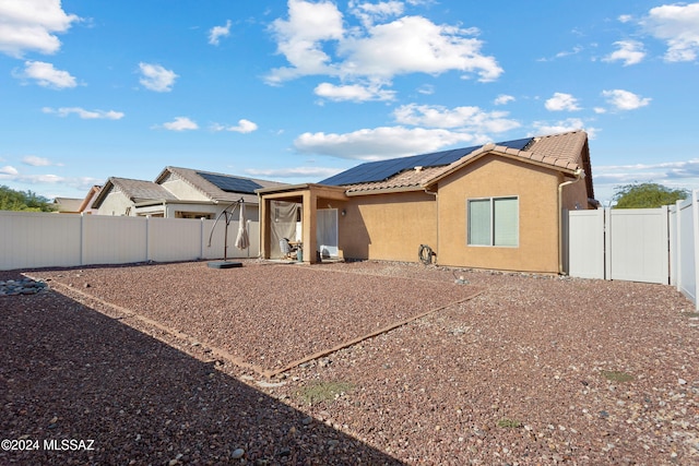 back of property featuring solar panels