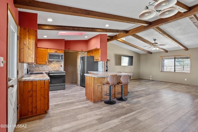 kitchen featuring sink, stainless steel appliances, lofted ceiling with beams, backsplash, and light wood-type flooring