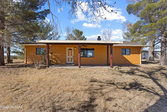 rear view of house with a lawn and ceiling fan