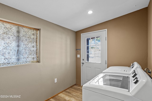 clothes washing area with separate washer and dryer and light hardwood / wood-style floors