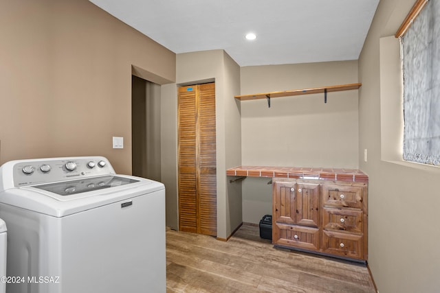 laundry area featuring light hardwood / wood-style flooring and washer / dryer