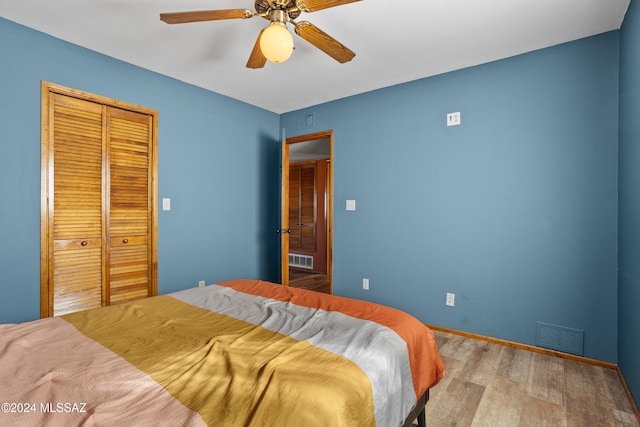 bedroom with light hardwood / wood-style floors, a closet, and ceiling fan