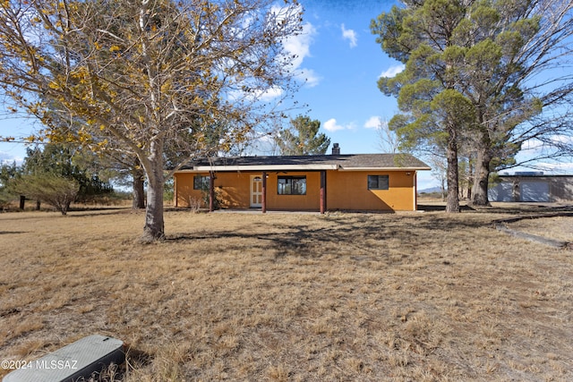 rear view of property featuring a yard