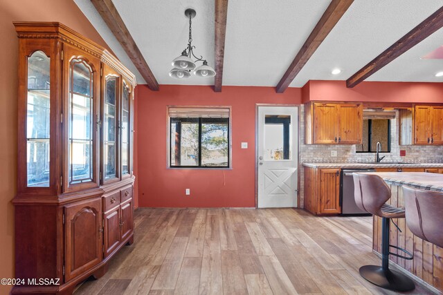 kitchen with pendant lighting, decorative backsplash, beamed ceiling, light hardwood / wood-style floors, and stainless steel dishwasher