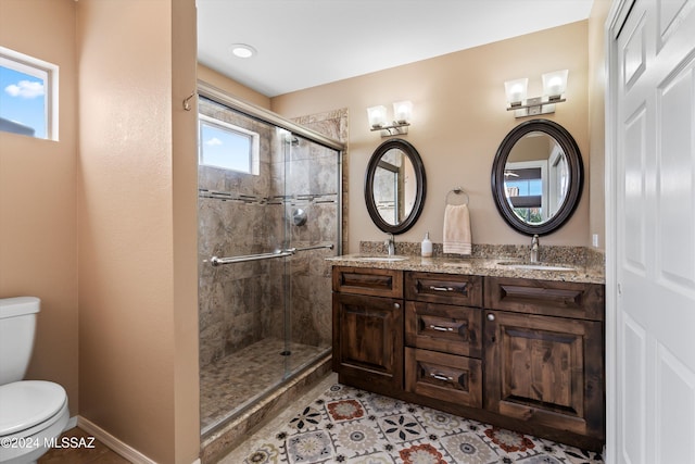 bathroom with tile patterned flooring, vanity, a shower with shower door, and toilet