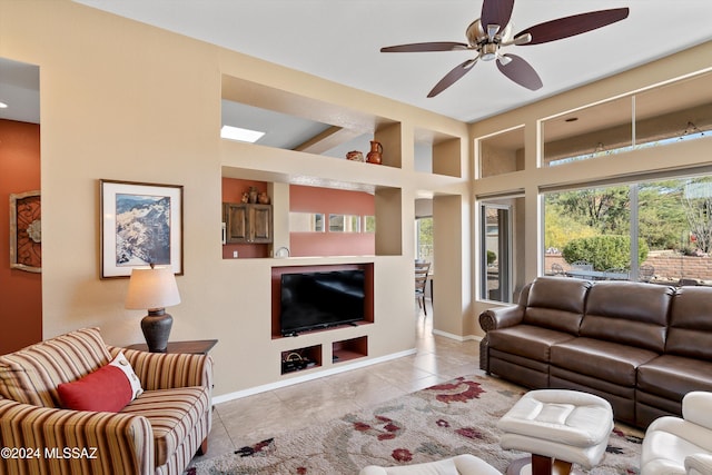 tiled living room with ceiling fan and a towering ceiling