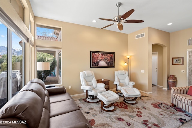 tiled living room with a mountain view and ceiling fan