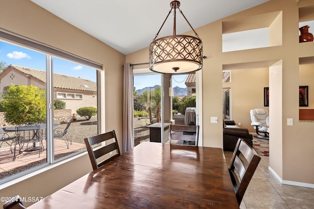 tiled dining room with lofted ceiling