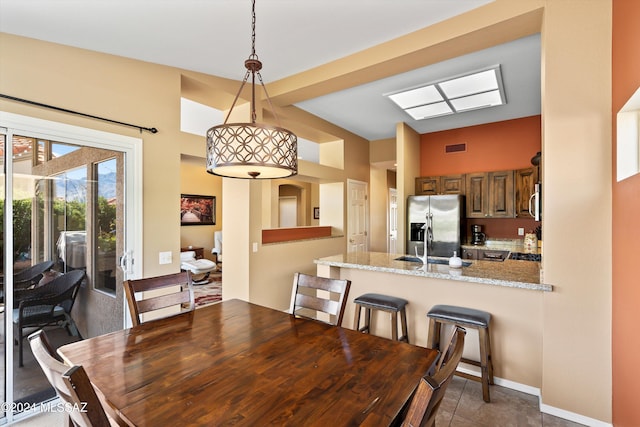 dining room featuring dark tile patterned flooring and sink