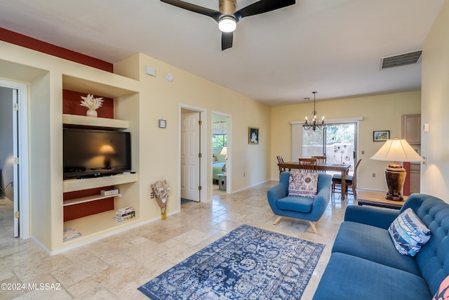 living room featuring built in shelves and ceiling fan with notable chandelier