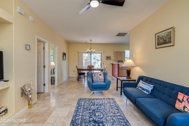 living room featuring ceiling fan with notable chandelier