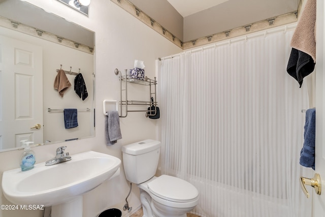 bathroom with a shower with shower curtain, toilet, and sink